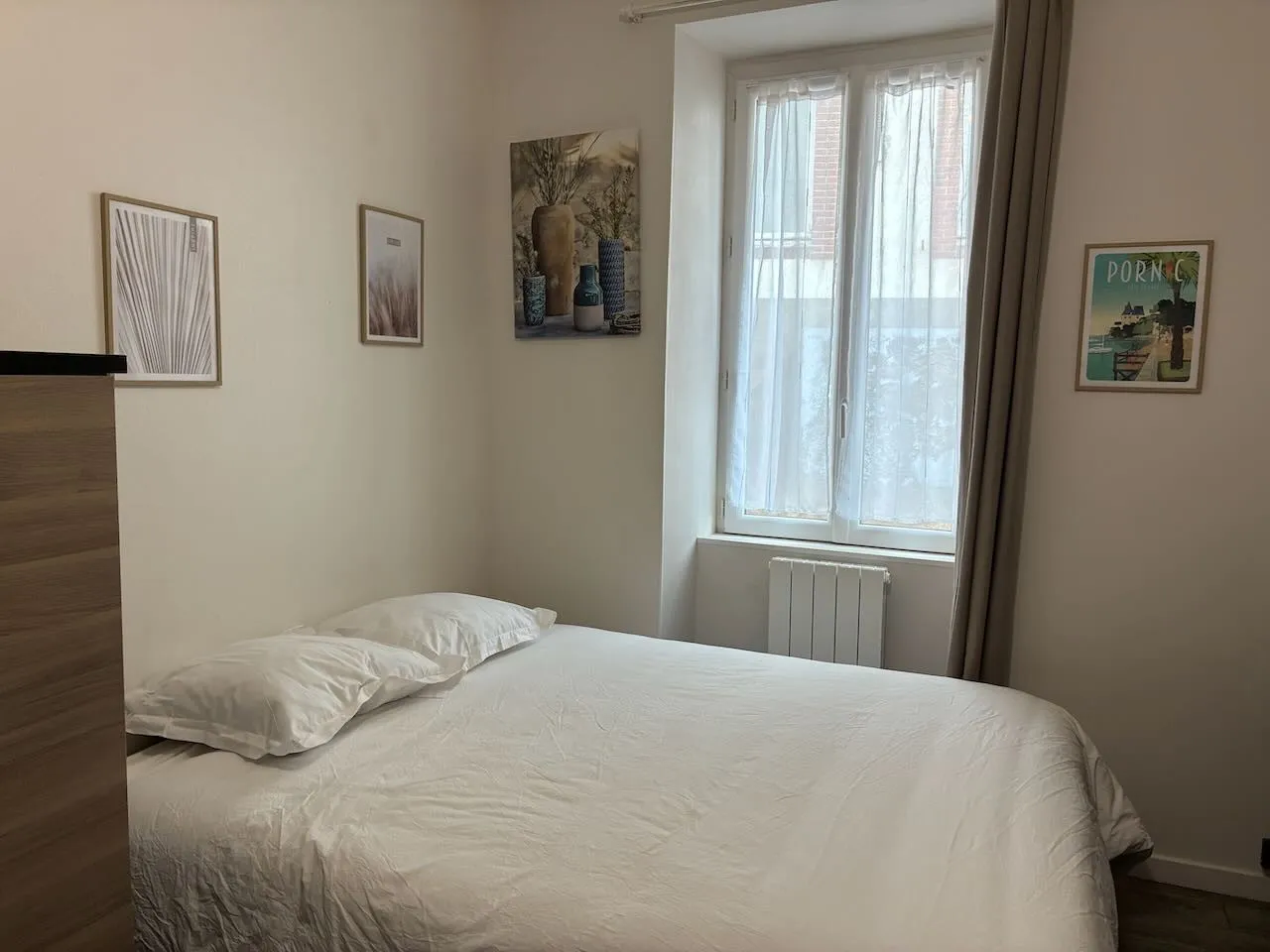 Le lit queen de 160 x 200 du Nid Galipaud, devant la fenêtre et son radiateur