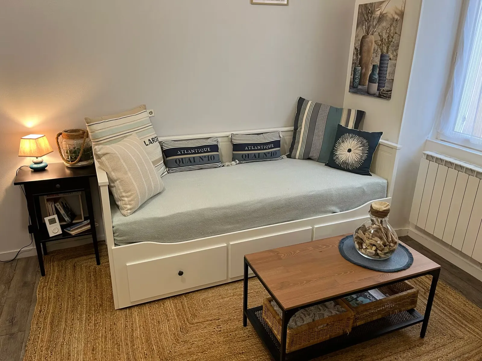 Living room of the Galipaud Nest: white sofa bed, nautical cushions, coffee table and jute rug