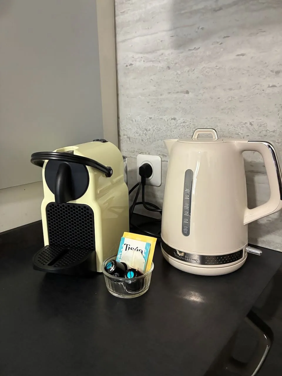Machine Nespresso, bouilloire, capsules et sachets de thé sur le plan de travail