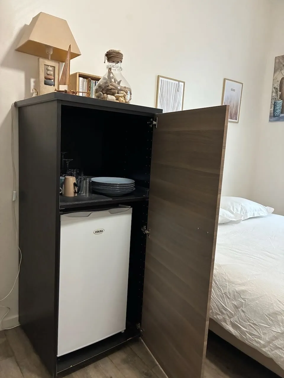 Armoire ouverte sur le réfrigérateur, les assiettes, les tasses et les verres